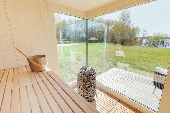 Blick ins Innere einer modernen Sauna mit Glasfront und Außensitzbereich. Blick ins Innere einer modernen Sauna mit Glasfront und Außensitzbereich.